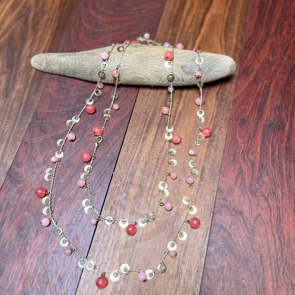 Pink and coral beads on gold colored chain. Beads are plastic